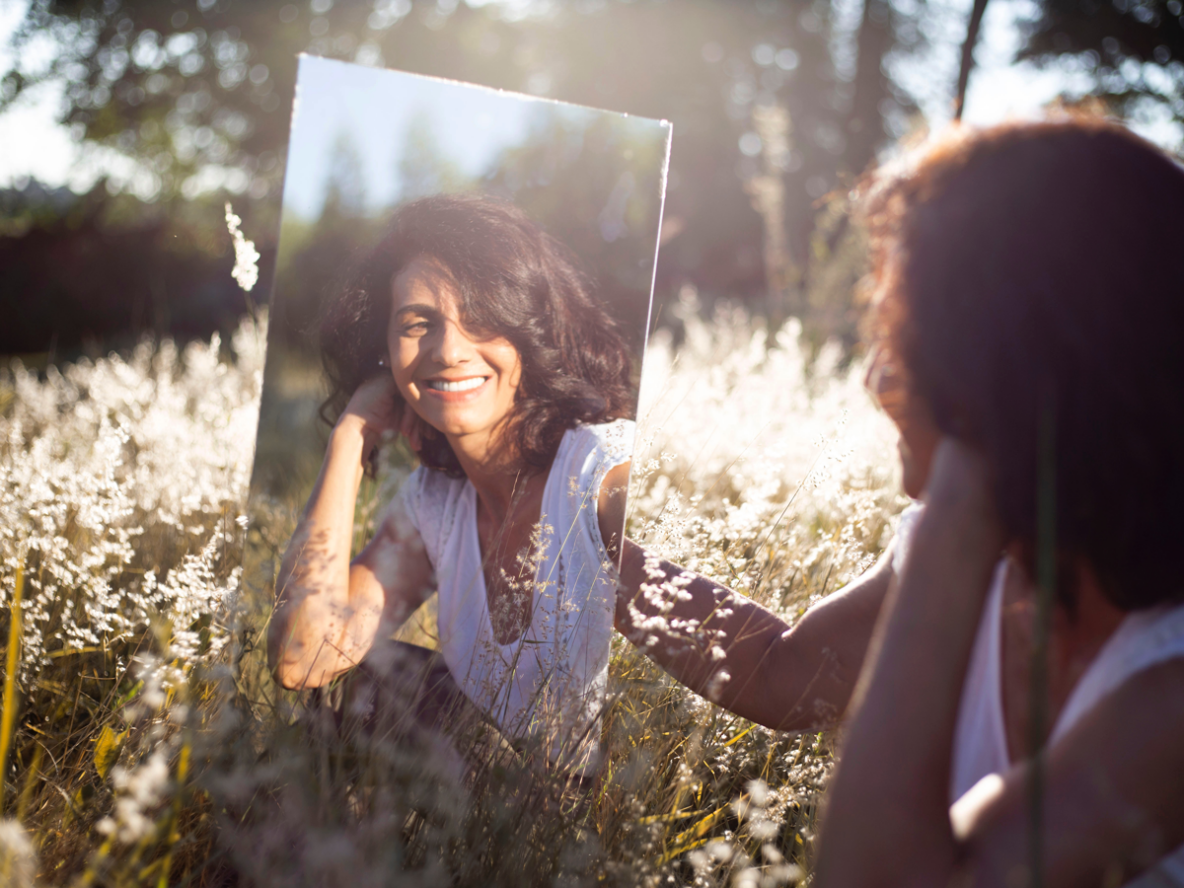 Older woman outside looking in mirror